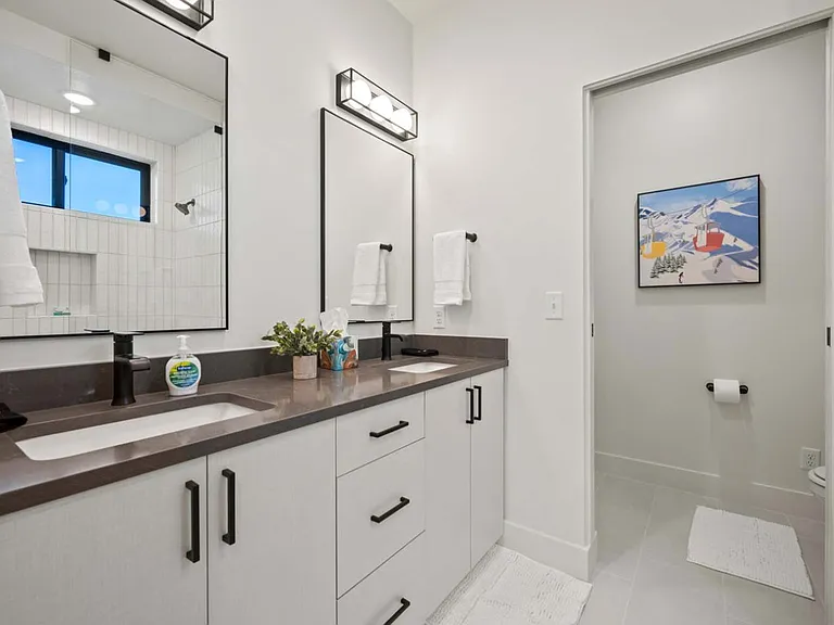 Master Bath with his and hers sinks, walk in shower, and separate toilet room