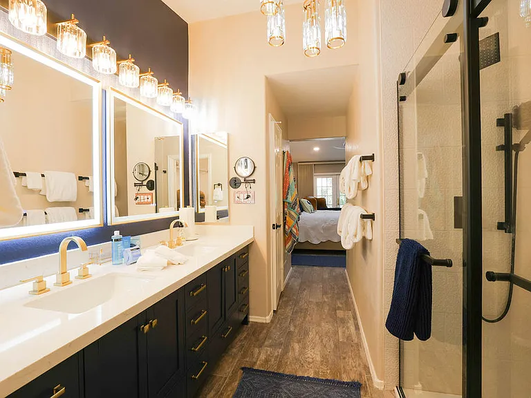 Master suite bath with rain head shower, hand held shower, safety rails, 2 sinks with LED mirrors, 10x magnifying mirror, 2 medicine cabinets, blow dryer, towels for 2
