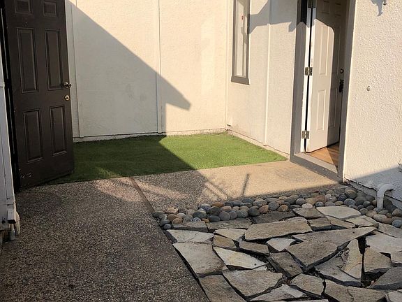 Front door entrance in gated courtyard. Entrance to garage located on left side (brown color door).