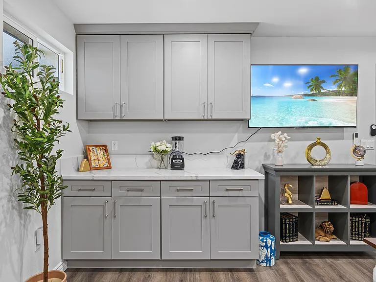 Start your day with a cozy corner featuring cabinets and a TV for your entertainment.