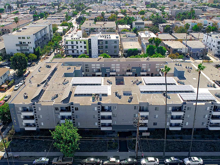 Over head drone shot of building with solar panels on roof.