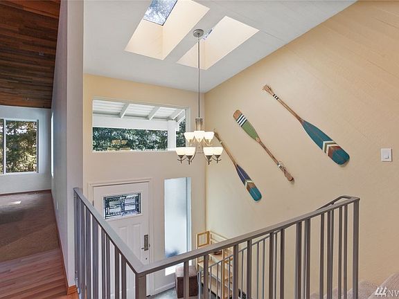 The entry for this home is filled with natural light from large skylights and high windows. Updated metal banister adds to the open feel of the entry.