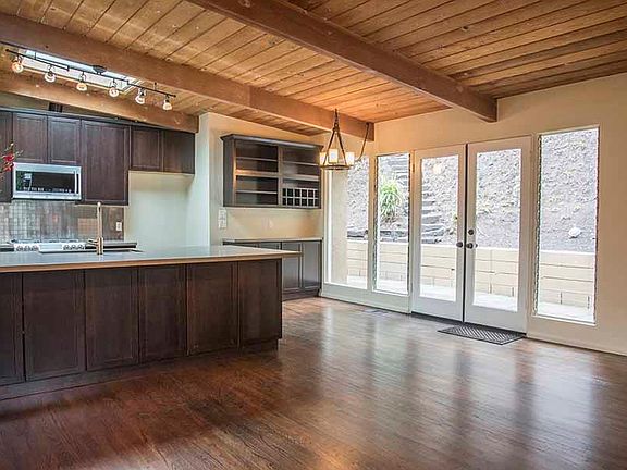 Open floor plan with beautiful wood floors & beam ceilings