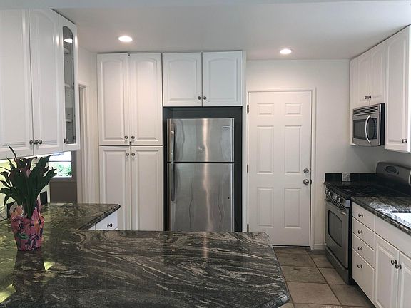 Kitchen with door leading to garage with laundry