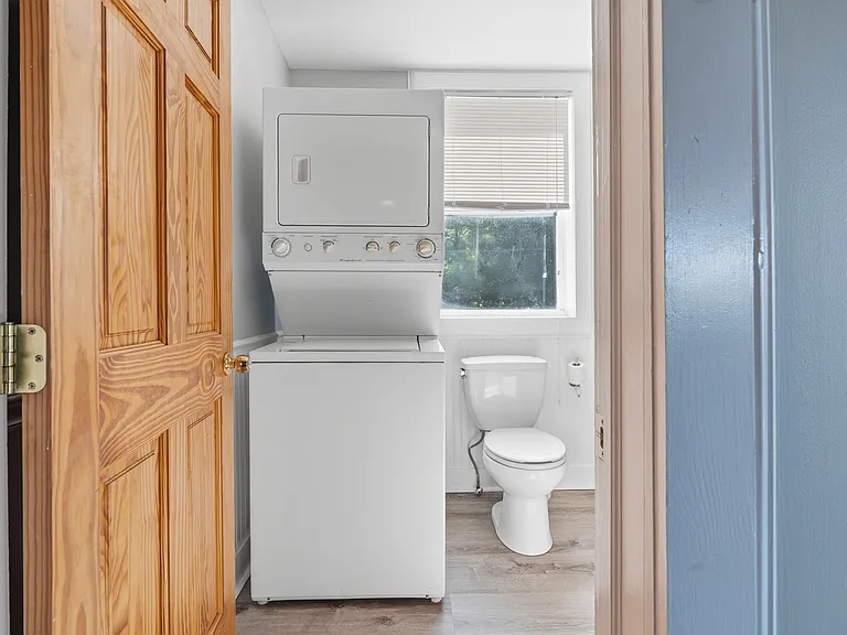 In-unit Washer and Dryer are conveniently located on one side of the large bathroom.