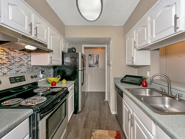 Fully equipped kitchen with designer backsplash, stainless steel front appliances, and ample cabinetry for extra storage.