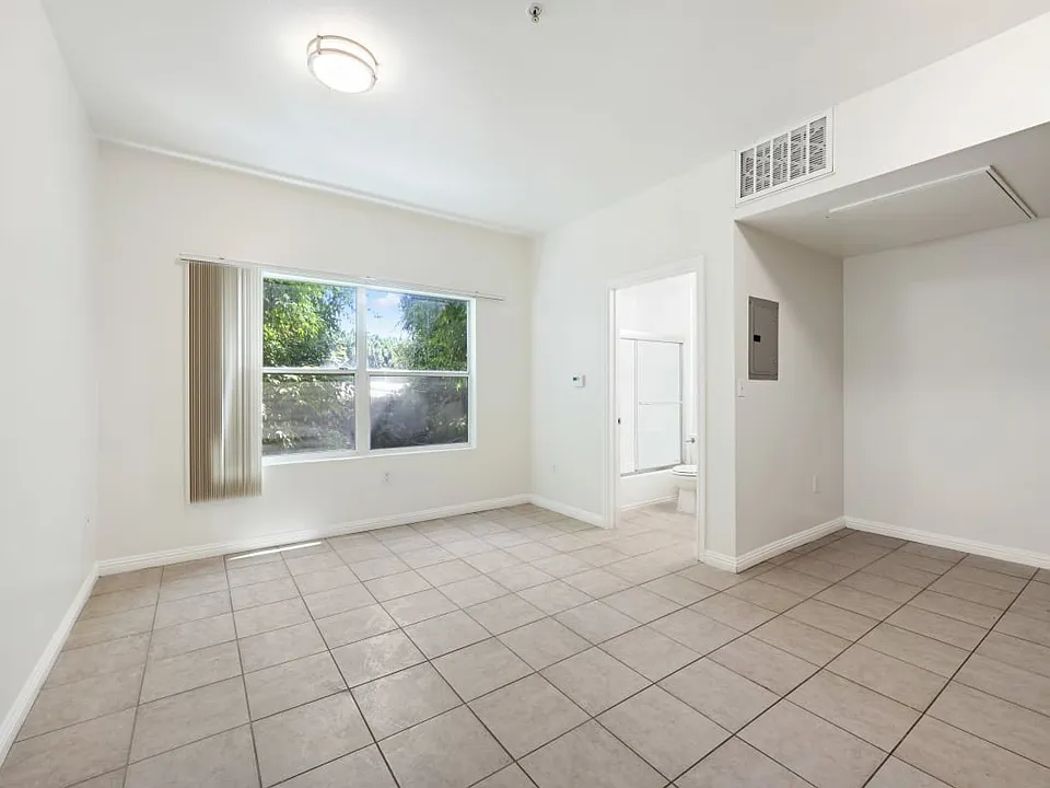 Burlington a bedroom with a large window and a tiled floor