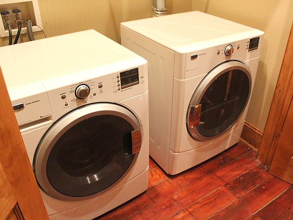 Updated washer/dryer with French door access. Located in hallway.