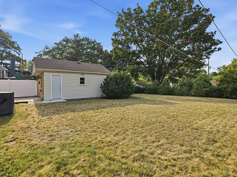 Evergreens line the back and the right (east) side of the property line. Large flat functional backyard with beautiful tree views, great for entertaining or relaxing after work.
