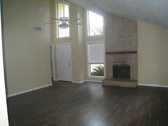 Large Family Room (18x15) with soaring vaulted ceiling and lots of windows to make it light and bright.  Also features recent laminate floor (walnut color) and  eye-catching wood burning fireplace with brick chimney all the way to the ceiling.