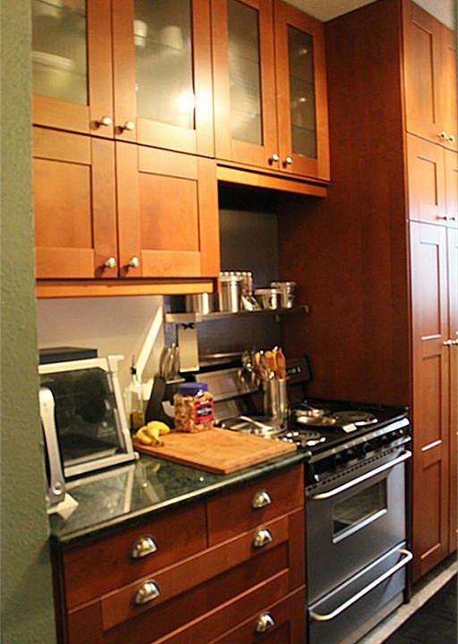 This kitchen includes custom cabinets, stainless steel appliances, marble countertops and new cerami