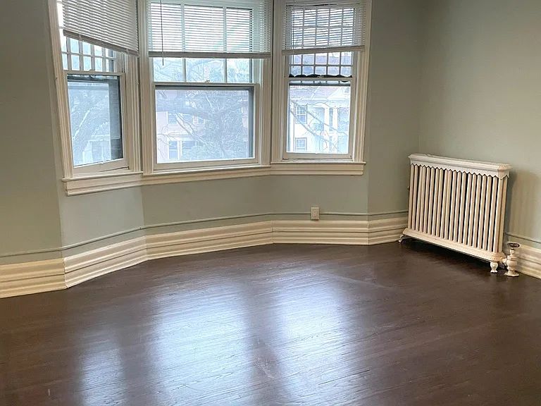 Primary bedroom with treetop views - sunny south-facing bow window.