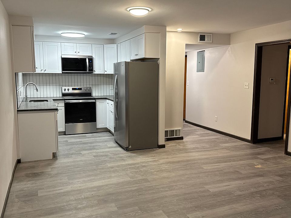 kitchen and living room, with hallway at center to entry, and hallway at right to bathroom and bedrooms