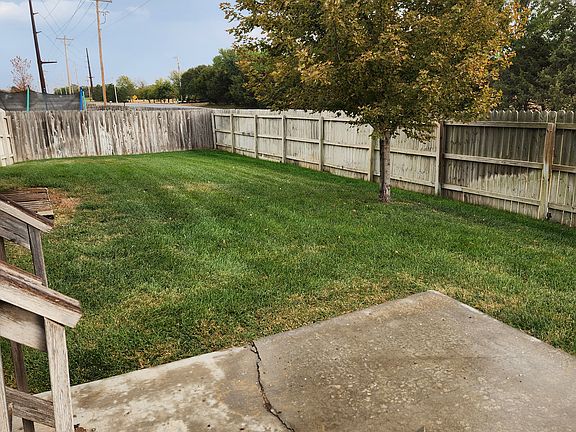fenced backyard with mature tree