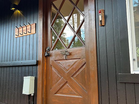 Charming cabin entrance with a classic wood door and rustic details, welcoming you into the cozy Big Bear retreat. Perfect mountain vibes start the moment you step inside.