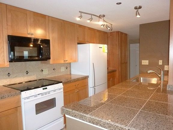 Impressive granite tile counters with granite backsplash. Stunning new kitchen cabinet doors. New ap
