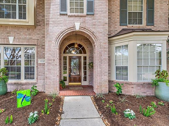 The entry features a full leaded glass front door, side lights, and arched transom.