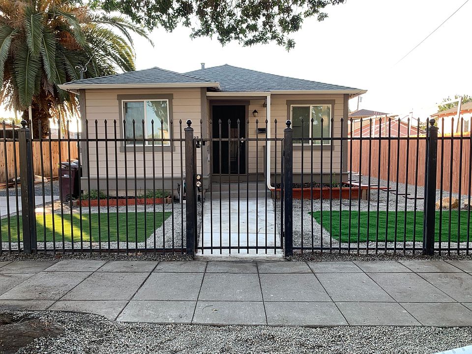 Front of home with security fence that surrounds the home.