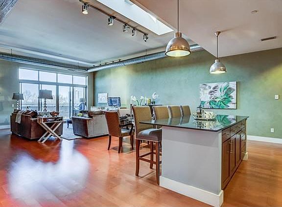 True loft style condo living at its best with 11' ceilings, double vaulted skylight, exposed wood beams/duct work and wide open floor plan