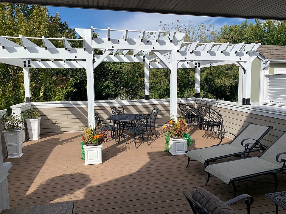 Rooftop Deck with Pergola ourdor dining swing chairs,sun lungers and seating around outdoor TV