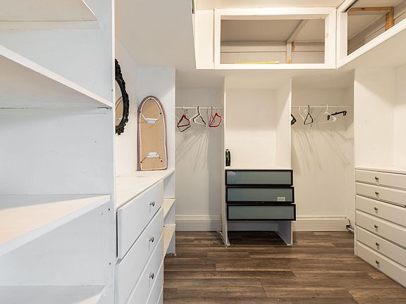 Walk-in closet with built-in shelving, drawers, and dual hanging rods, offering practical storage for clothing and essentials