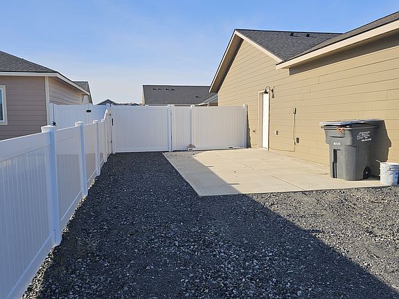 Concrete RV pad with water, sewer access pipe capped, and electrical socket on wall.