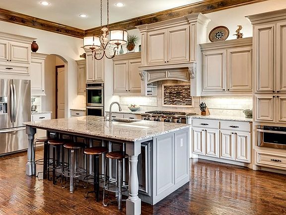 Refreshing, modern kitchen with custom painted breakfast bar-island, tea stained cabinetry, stainless steel commercial grade appliances and top of the line granite counters.