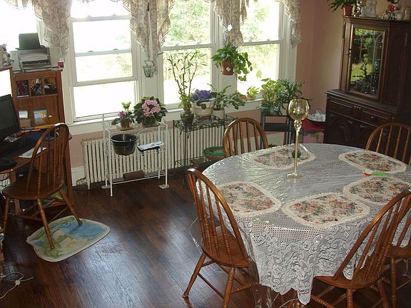 Spacious dining room with a wall of windows and a beautiful hardwood floor.
