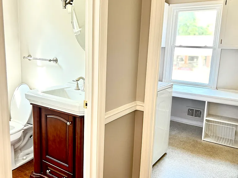 The 1/2 bathroom or guest bathroom next to the separate laundry room with shelves in the main floor access to the kitchen.
