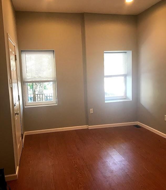 Living room with new floors - well lit with windows overlooking front porch.
