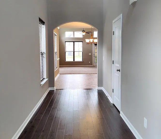 Enjoy the long foyer that leads to the arched entrance to the eat-in kitchen.