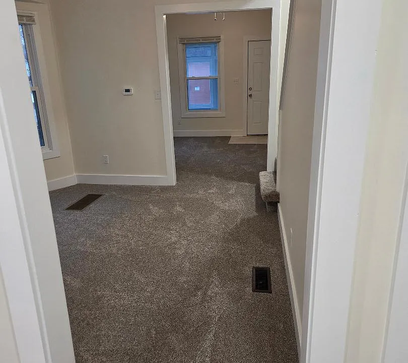 view of dining room and living room and front door from kitchen