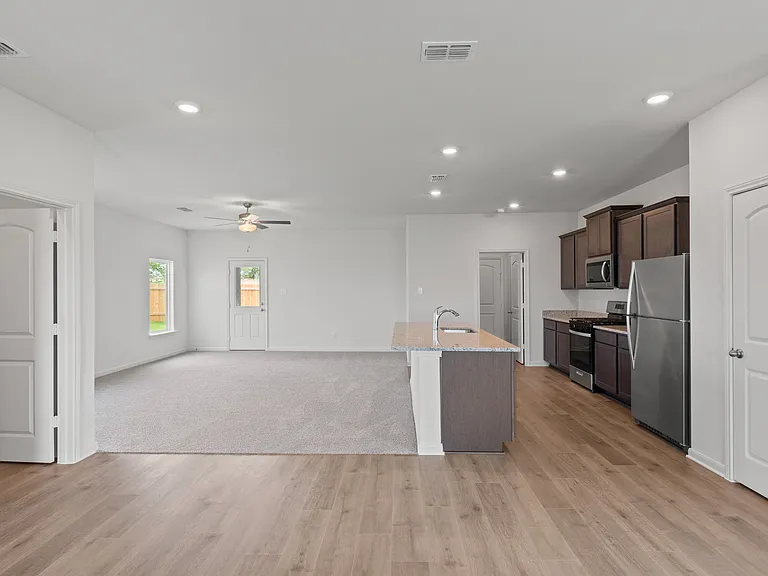 The open-concept layout of this floor plan has the kitchen, family room and dining room sitting next to one another.