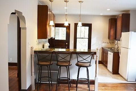 eating island. Door on left leads to hall off of which are two rooms (bedrooms or office) and the full bath.