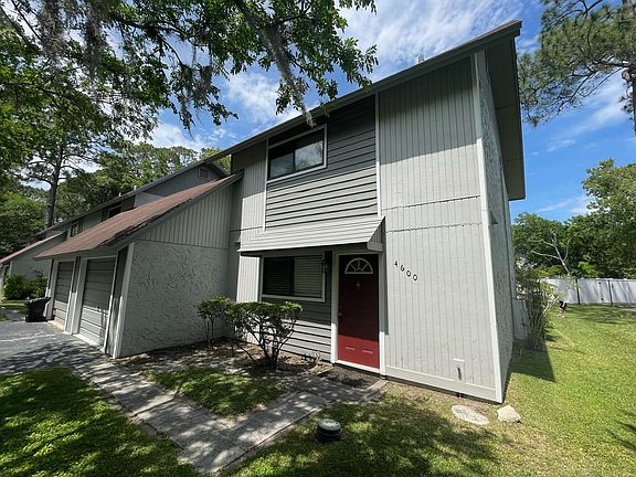 Front of home showing attached one car garage, end unit, and extra parking