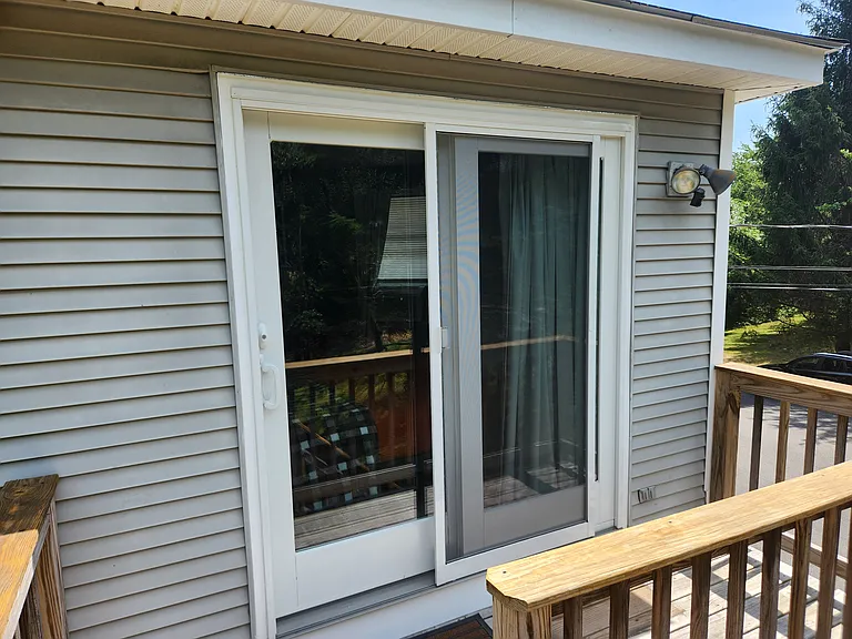 Bedroom 3 with queen bed on second floor, separate entrance, mini-fridge, mircowave, smart TV, fold away table and chairs, shower stall, bathroom sink, toilet, and views of backyard.