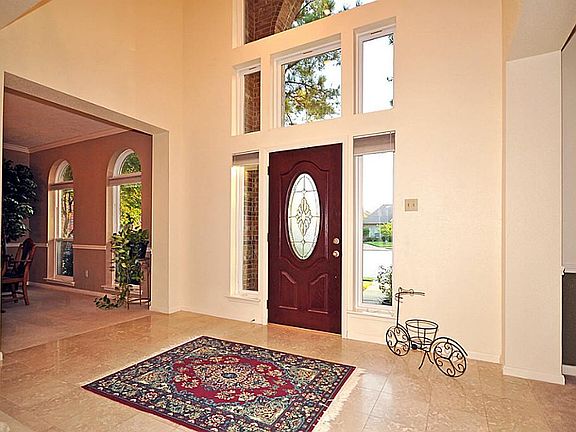 This impressive entryway boasts a  beveled door, high windows and 2 story ceiling.