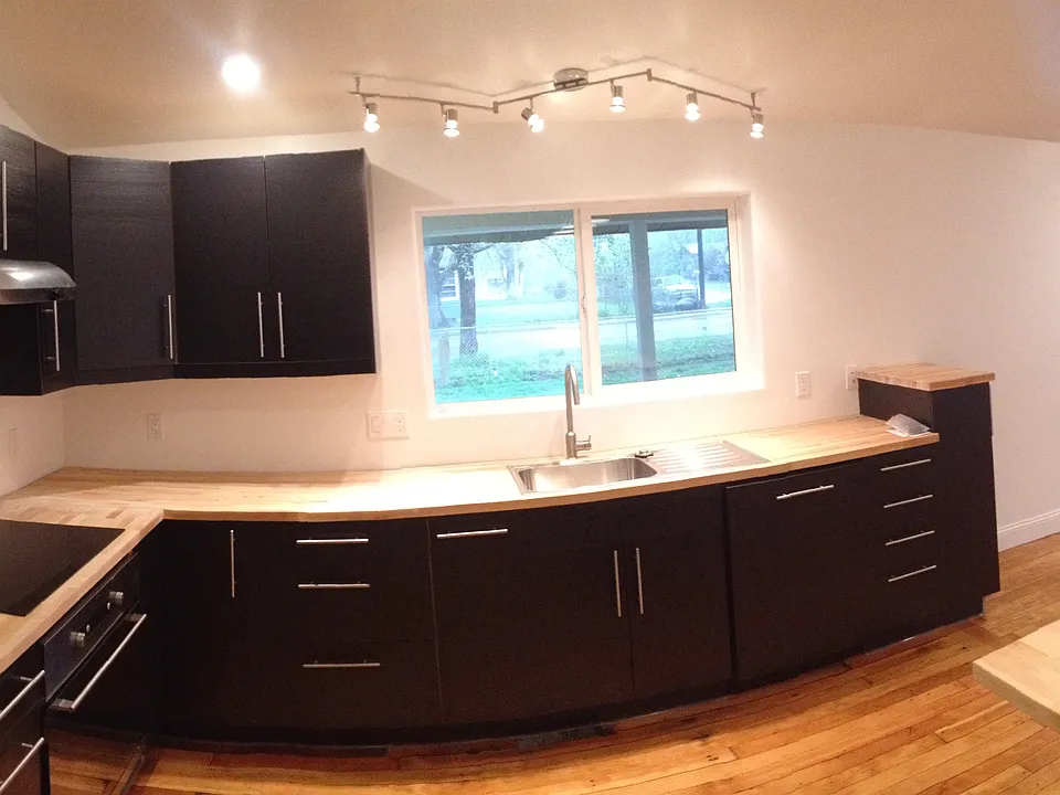 Entry, mudroom, laundry, and half bath on the left. Kitchen center with large island, and living room right.