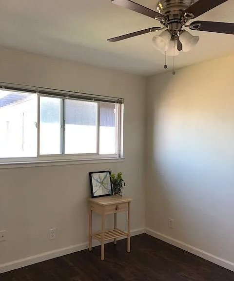 Second bedroom has a large window, wood laminate flooring, ceiling fan and 5 foot closet.