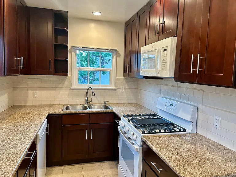Kitchen: Stove, microwave, plenty of cabinets and modern sleek sink