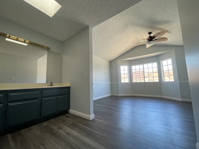 MBR upstairs facing towards front of home, bathroom sinks on left, ceiling fan