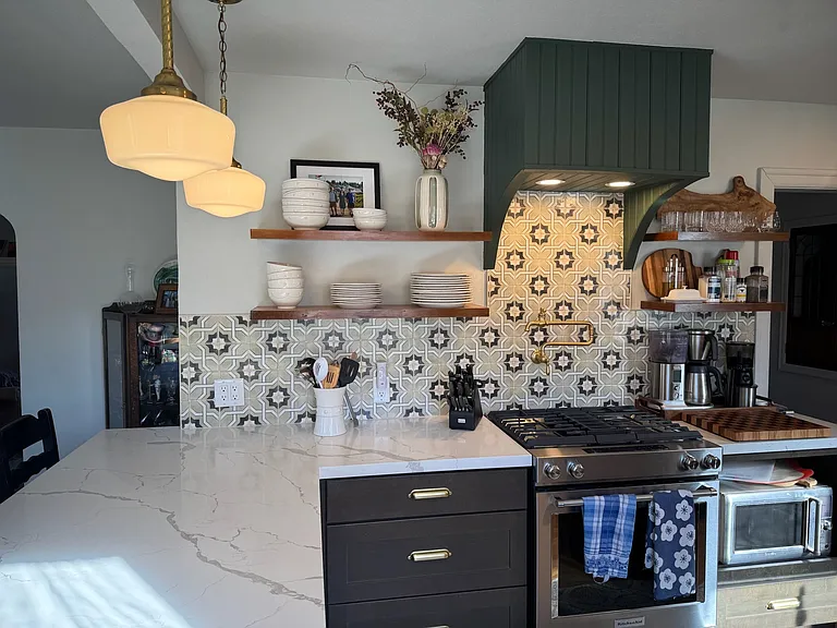 Gas range, open shelves and beautiful tile backspash