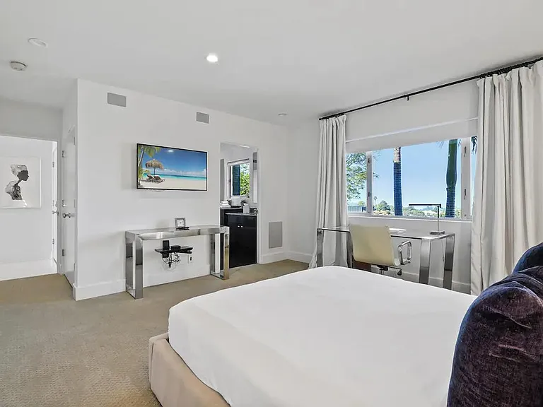 Enjoy the spacious bedroom equipped with a TV and blackout curtains, creating a comfortable and restful sanctuary.