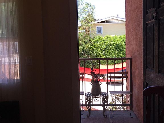 Entrance in the foyer/ office/ bonus room - loveseat by the left window, table with chairs, small computer desk.