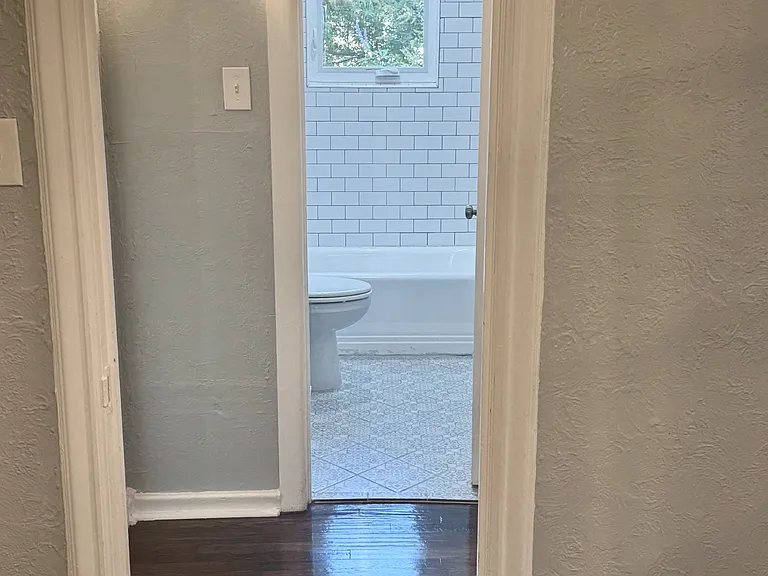 View coming from the dining room and looking into the bathroom, with the bedroom to the left.