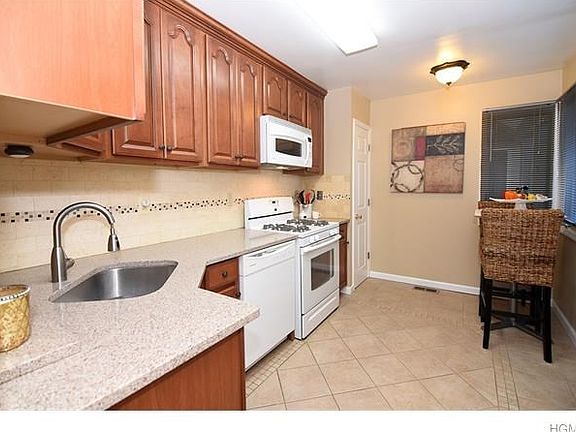 Updated kitchen with custom cabinets, granite counter tops, tiles back splash, tile flooring and large pantry closet.