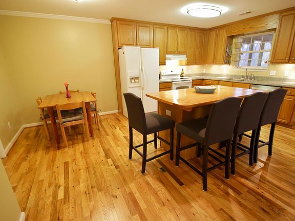 Kitchen: hardwood floors, island with counter stools, breakfast nook