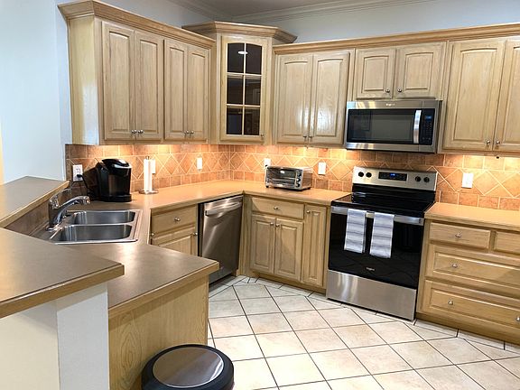 Kitchen includes recent stainless steel appliances.