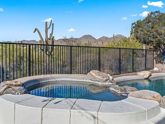 Backyard _ Feel the difference in your skin and swim in the Saltwater pebble-tec pool with two lagoons that allow umbrellas for additional shade. Soak in the 8-person spa with a beautiful waterfall feature. Pool Capable of being heated