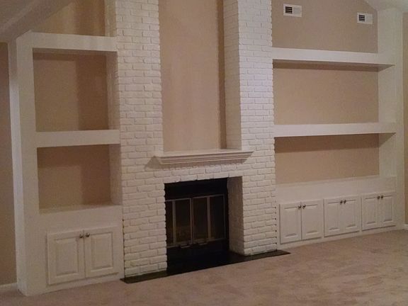 Huge built in bookcase in living room. Carpet has been replaced with wood floors
